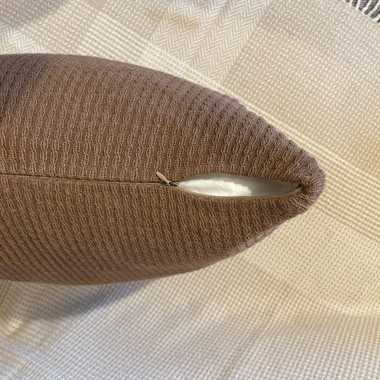 Brown Alpaca cushion cover zoomed in with zipper and slightly uncovered.