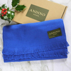 Royal blue alpaca wool scarf on top of its Andino alpaca box on a white marble table