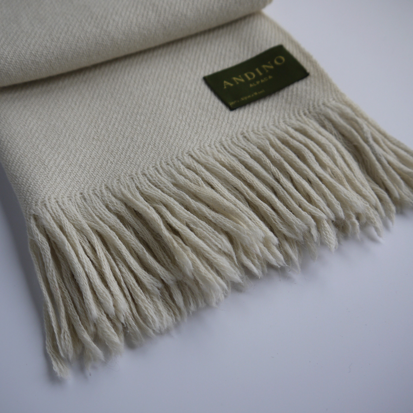 Zoomed in cream long extra large alpaca wool scarf on a white background