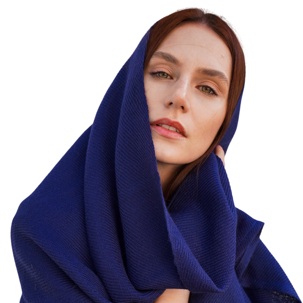Young woman wearing alpaca throw over her head as a scarf.